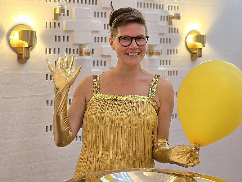 Pia Sonne Juulsen i guldkjole med guldballon